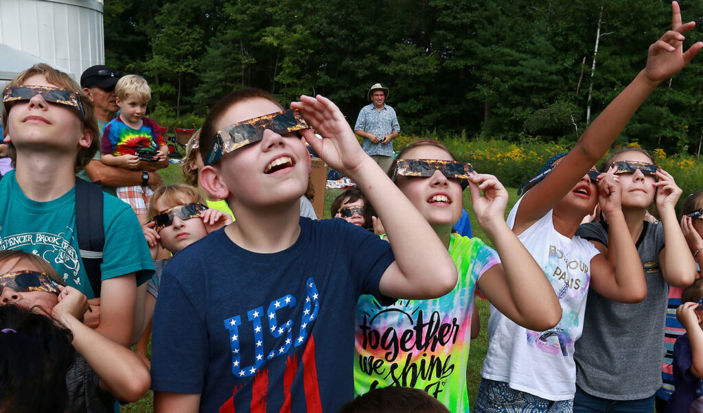 Kids watching an eclipse through paper safety glasses