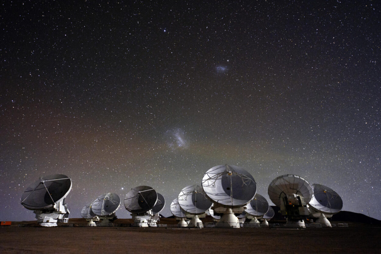 A large group of radio telescope dishes against the night sky