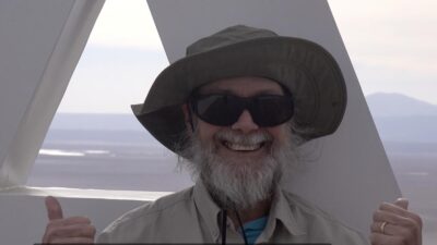 A typical MIT radio astrophysicist in a hat giving two thumbs-ups